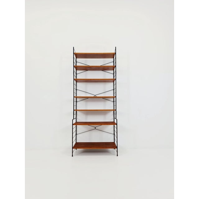 Freestanding vintage string bookshelf in walnut , 1950s by whb germnay dimensions: 30--39 d x 73 w x 180 h cm it is in...