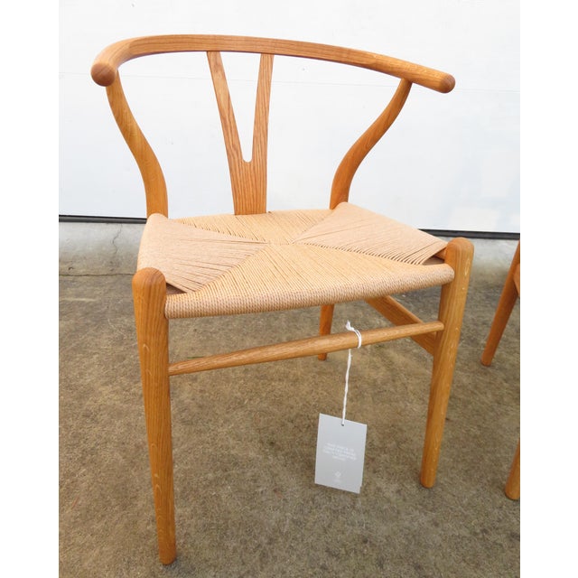 Authentic pair of Carl Hansen CH24 Wishbone dining or side accent chairs, designed by Hans Wegner. Excellent condition,...