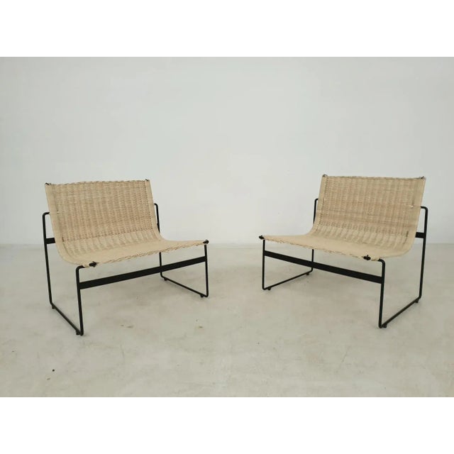 Very rare pair of black metal lounge chairs with rattan seatings, design by the Spanish Gregorio Vicente Cortes and Luis...