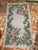 Colorful signed and dated hooked rug . Pretty floral accents . Background is a gray tone with red and green bold florals ....