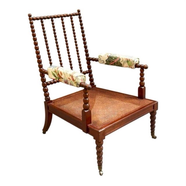 Victorian English armchair, circa 1880, made of hand-carved, wound mahogany. Seat with cane webbing and brass casters....