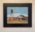 The artwork depicts a rural cotton gin, characterized by its vibrant red structures and a tall water tower against a...