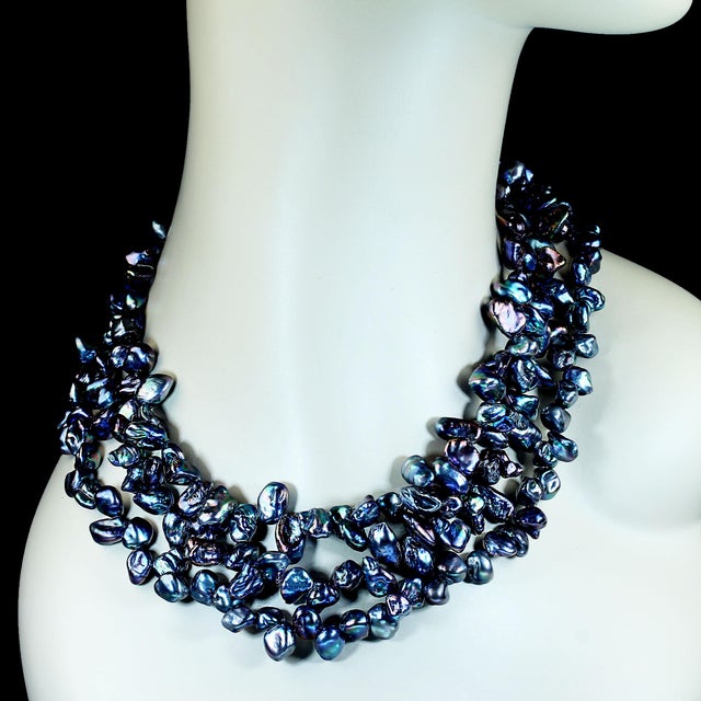 This elegant three-strand necklace showcases the natural beauty and unique character of genuine Peacock Keshi pearls. The...