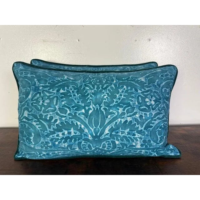 This elegant pair of pillows showcases a luxurious design in a rich teal blue hue. The front features a botanical and...