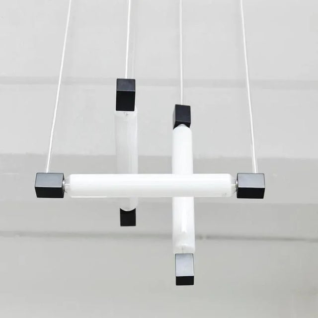 This pendant lamp in the style of Gerrit Rietveld was produced around 1960. The piece features a painted wooden structure...
