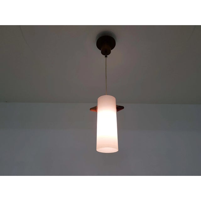 - Danish glass and wood pendant lamp - Glass tube and wooden elements - Diameter tube: 11 cm Up to 250V (Europe/UK...