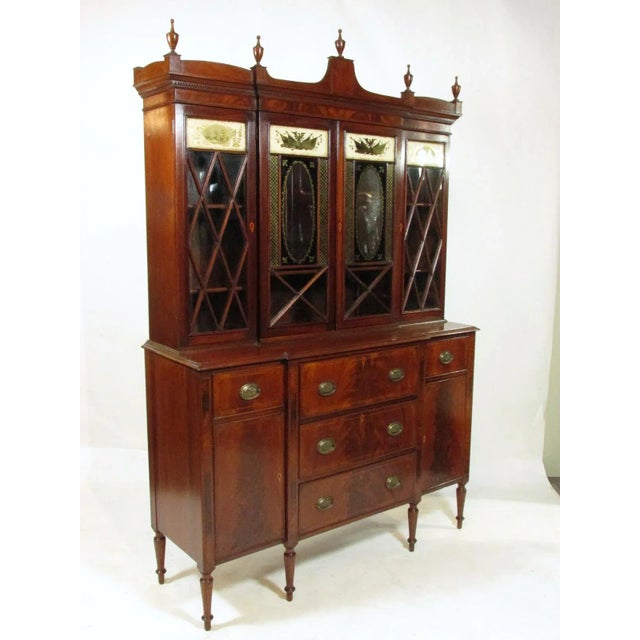 An early 20th-C.bench made Federal style inlaid mahogany breakfront with an upper section that features glazed mullioned...