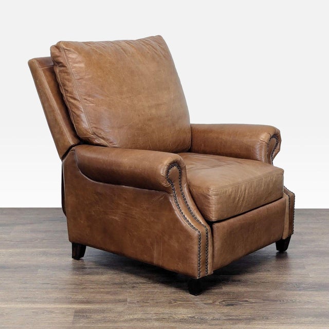 This Pottery Barn lounge chair features rich brown leather, classic rolled arms with nailhead trim, and a smooth reclining...