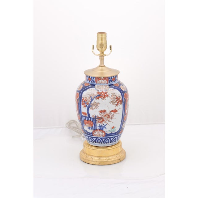 A vibrant pair of Imari porcelain lamps richly decorated with traditional floral and foliate motifs in cobalt blue and...