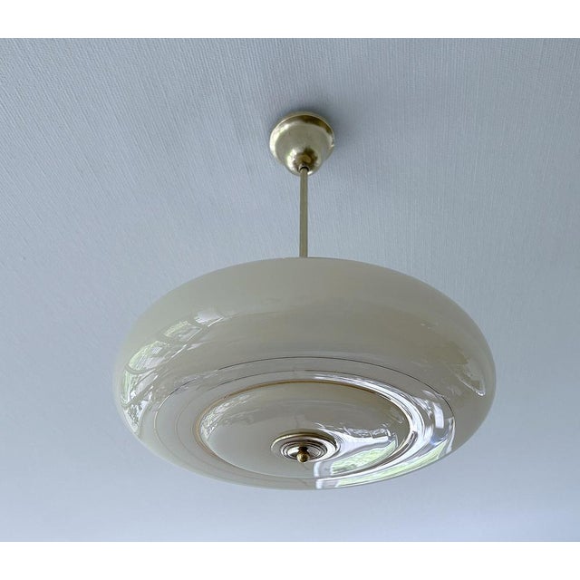 Art Deco pendant lamp from the 1950s, ivory glass shade with concentric gold patternss, brass structure Very good...