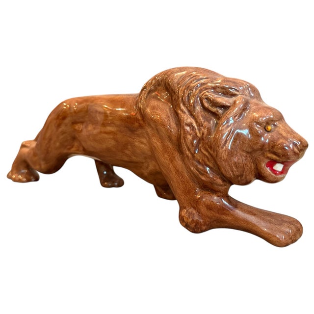 Striking vintage ceramic lion sculpture featuring a dynamic reclining pose and rich glossy brown glaze. The sculptor...