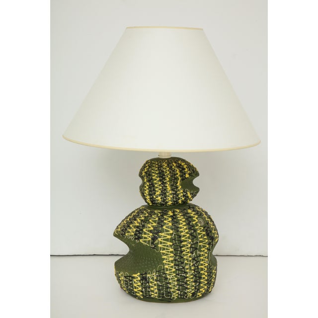 A vintage ceramic table lamp with a textured design in green, yellow and black. Italy, circa 1950. Includes paper shade....