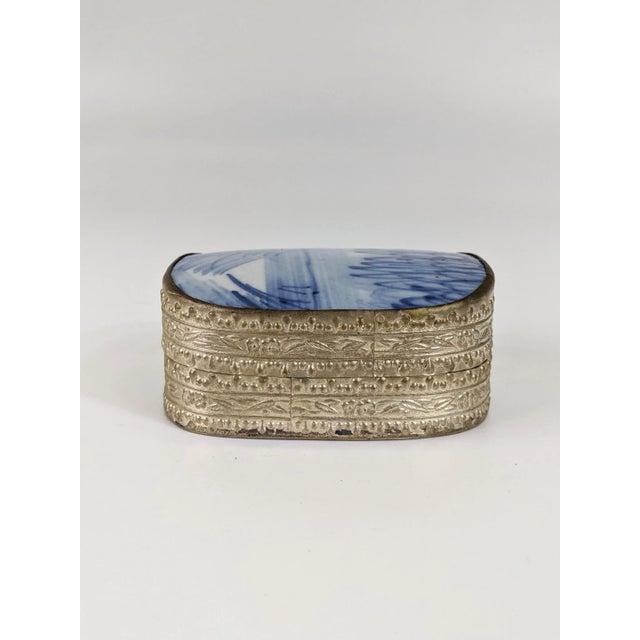 Lovely blue and white box made from a shard of porcelain from a vase or tile. The bottom is silver colored brass.