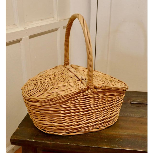A lined oval wicker picnic basket An attractive basket with 2 lidded sections and big handle, the basket is lined inside...