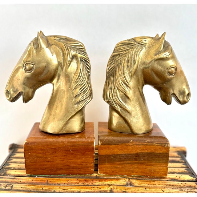 Striking and substantial pair of vintage brass horse head bookends mounted on solid wood bases. Marked “Dolbi-Cashier 1980...