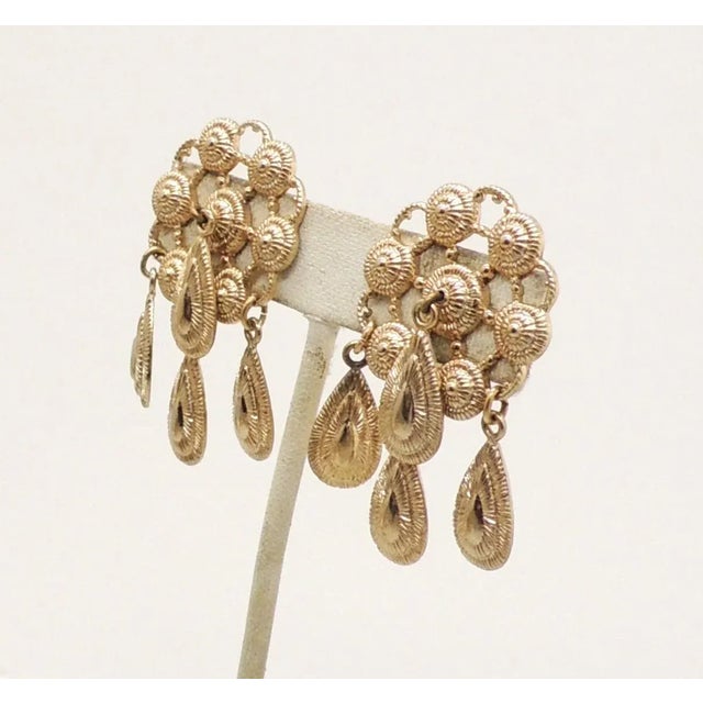 This is part of Chairish’s Costume Jewelry assortment. Circa 1970s goldtone open work tops with 3 drops on the bottom and...