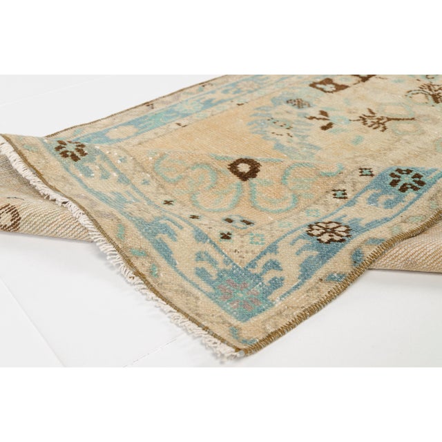 This is a vintage Turkish Oushak rug from the Mid 20th Century. The piece was hand-knotted.