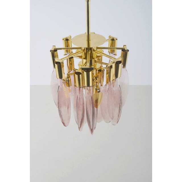 This Italian chandelier from the 1970s features a central brass metal frame from which 16 teardrop-shaped Murano glass...