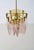 This Italian chandelier from the 1970s features a central brass metal frame from which 16 teardrop-shaped Murano glass...