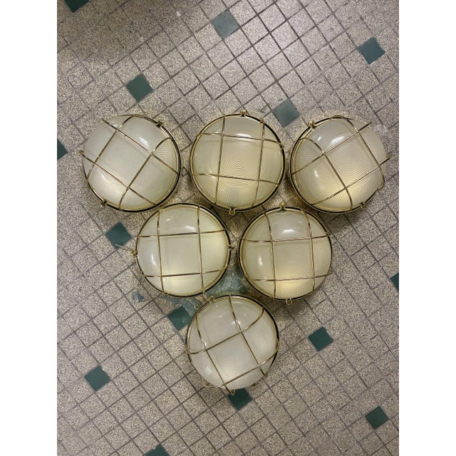 Gold-tone metal base supporting a glass half-globe. 1970s/80s. Electrical connection in perfect working order. In...