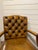 This is a lovely English leather arm chair. With a camel shaped tufted back, covered arms and decorative brass nailhead...