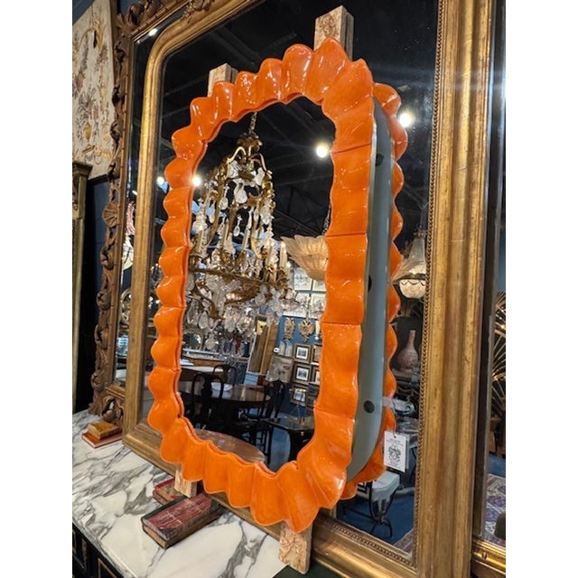 The Modern "Gucci" Orange Murano Glass Wave Mirror is a stylish and vibrant addition to any home decor. The vibrant color...