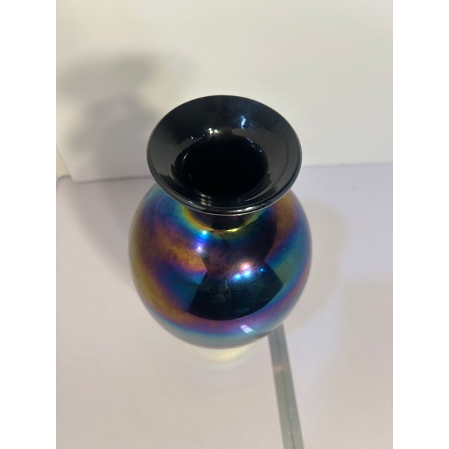 This striking hand‑blown iridescent art glass vase features a deep cobalt/amethyst base color with a dramatic metallic...