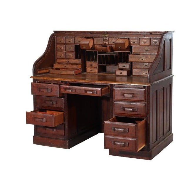 An antique Arts & Crafts roll top desk, crafted from distinctive quarter sawn oak, dating to approximately 1910. This...