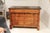 A striking example of French Empire craftsmanship, this 19th-century walnut commode combines bold architectural lines with...