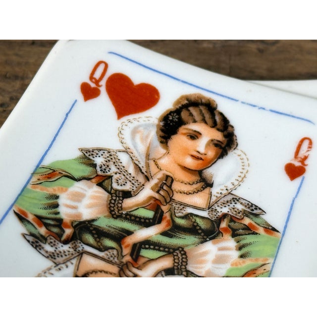Vintage porcelain ashtray featuring a Queen of Hearts playing card motif with black spade accent, likely mid 20th century....