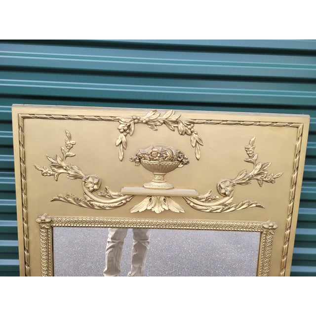 Antique large Trumeau French style mantel or wall mirror. Features gold finish with floral drapes above a large square...