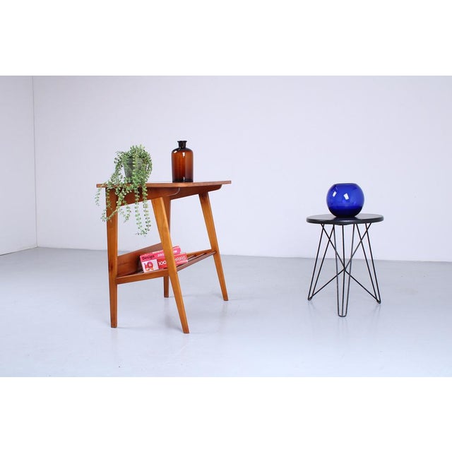 A charming 1950s side table with integrated magazine rack. Crafted from a light-toned wood such as alder or beech, this...