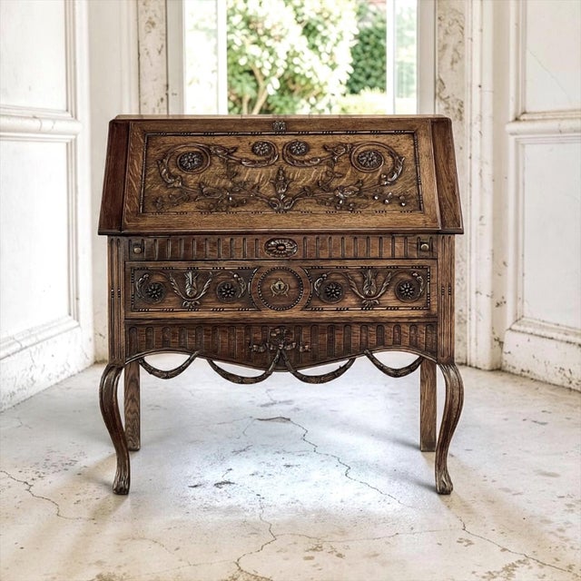 A 19th century Country French Louis XVI secretary carved from solid old growth oak, its warm, mellow patina glowing across...