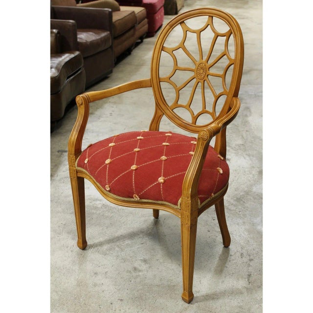 This carved wood accent chair features an oval backrest with a radiating medallion design that creates a striking...