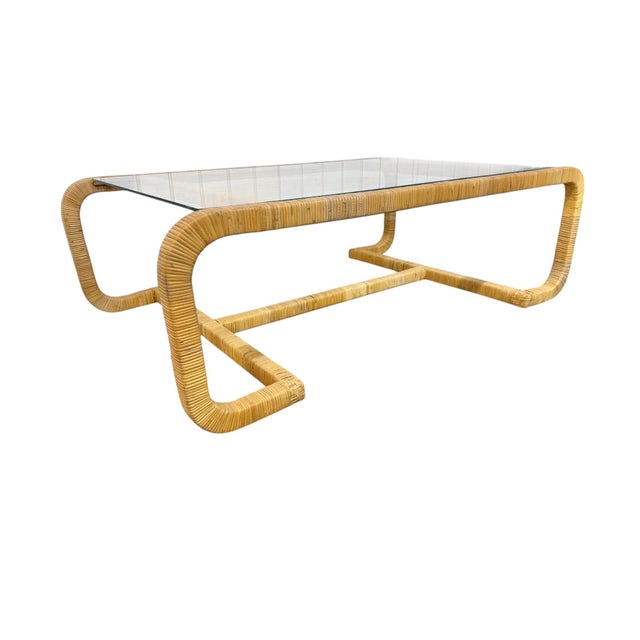 Elevate your living space with this striking Mid-Century Modern rattan-wrapped glass top coffee table, crafted in the...