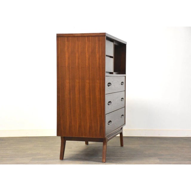 A mid century modern walnut tall dresser with canted legs and steel drawer pulls made by Hooker Furniture. 42” wide. 18”...