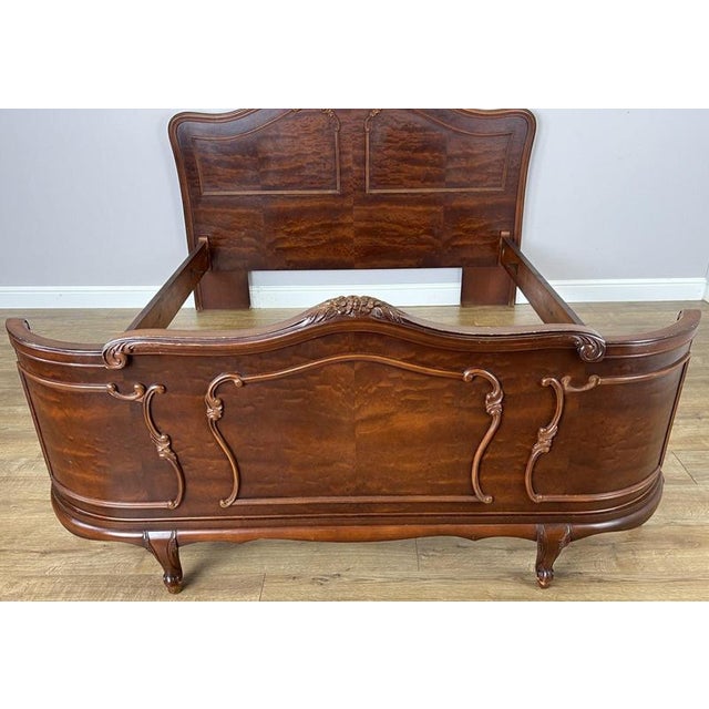 An elegant Vintage French Louis king size bed featuring a beautifully shaped headboard and footboard, flowing curved...