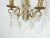 One pair of bronze appliqués or wall sconces. They have an etched curved base and all the crystal sconces are intact....