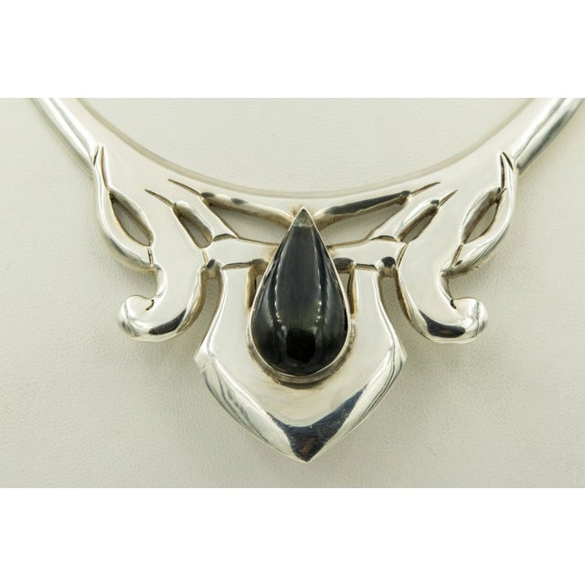 This stunning necklace has a modernist design in the center with a pear shaped rainbow obsidian in the center. It is...