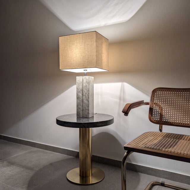 This table lamp base is carved from solid white Carrara marble and built as a series of slender rectangular columns of...