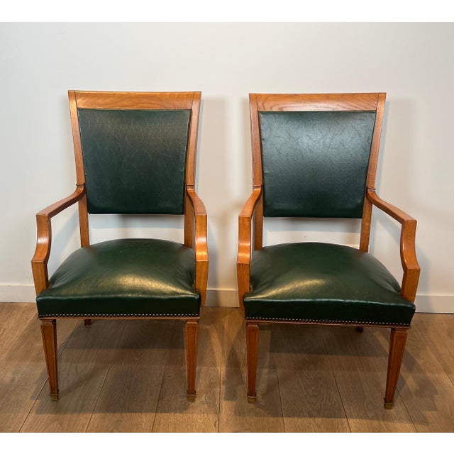 This beautiful and elegant pair of neoclassical armchairs is made of oak and leather. It is a Belgian work by De Coene...