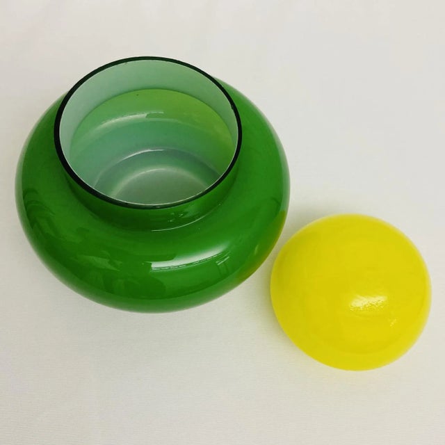 This Vintage Green Enesco Cased Glass, Mid-Century Jar has a yellow lid. Elevate your home decor with our Vintage Green...