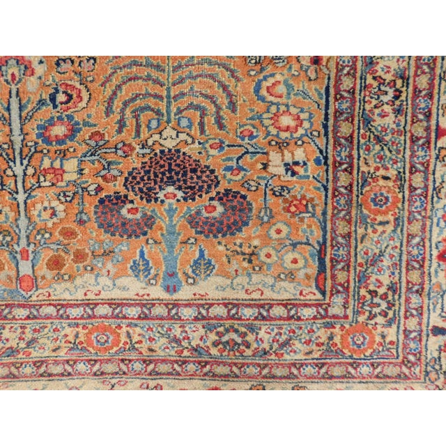 Antique Persian rug with an allover floral pattern on a rust field, within floral decorated ivory border.
