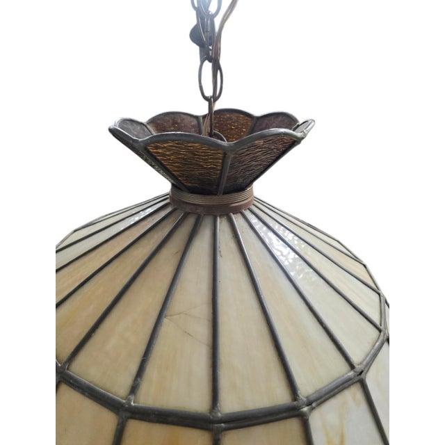Beautiful vintage 1970s Tiffany-style hanging pendant light featuring cream slag-glass panels accented by textured amber...