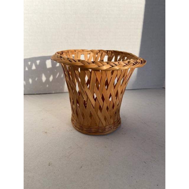 A single vintage woven rattan cachepot with flared sides. Diameter at interior base is 3.25”.