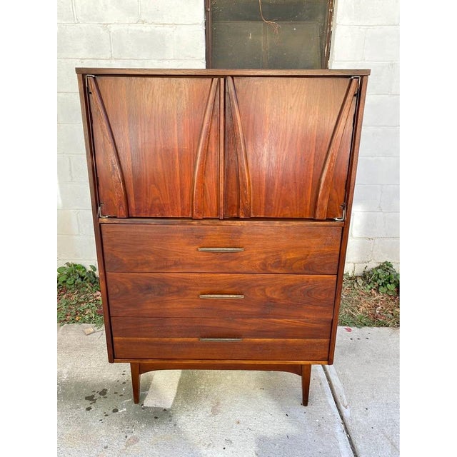 Description: This vintage Mid-Century Modern gentleman’s chest is a refined, functional storage piece with strong...