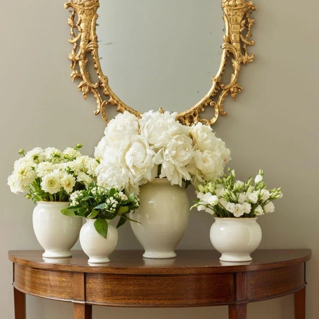 Hand thrown, each vase has a wide rim and has subtle ribbing on the surface, giving it an artisanal quality, while the...