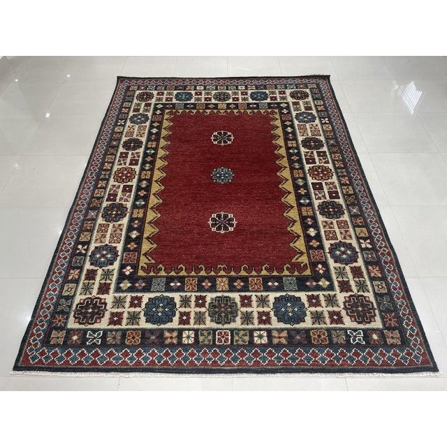 This hand knotted pile rug features a primary color palette of coral, salmon, and pink. Made from wool, this Sarouk style...