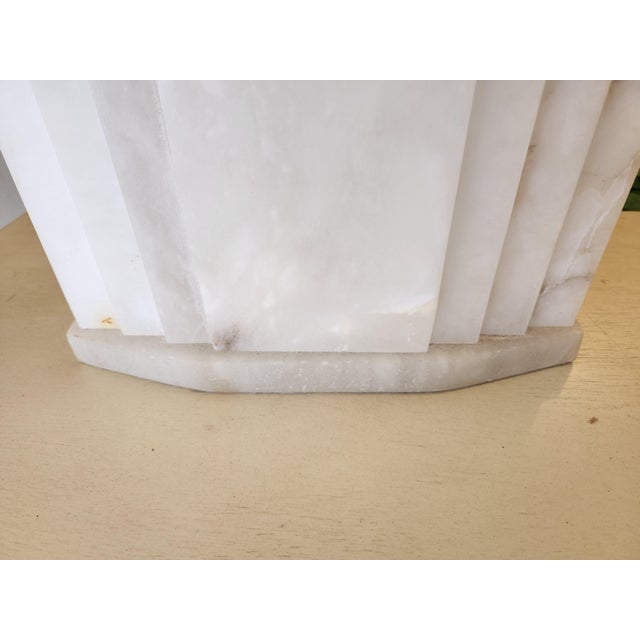 The design features a custom carved alabaster lamp with a matching alabaster lamp base. It includes a bronze-colored rod...