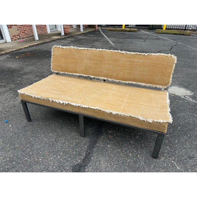 A refined vintage upholstered bench showcasing textured natural linen upholstery finished with softly frayed fringe edges...